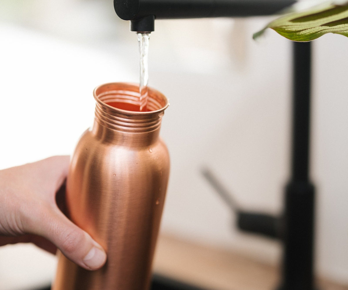 Kopero Koperen Waterfles Glad, onder de kraan, terwijl er water in stroomt