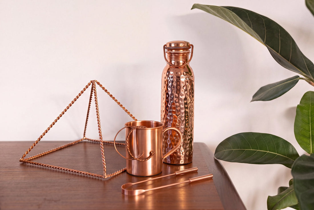 Koperen tongschraper, piramide, mok en waterfles uit de Kopero-collectie samen op een houten tafel