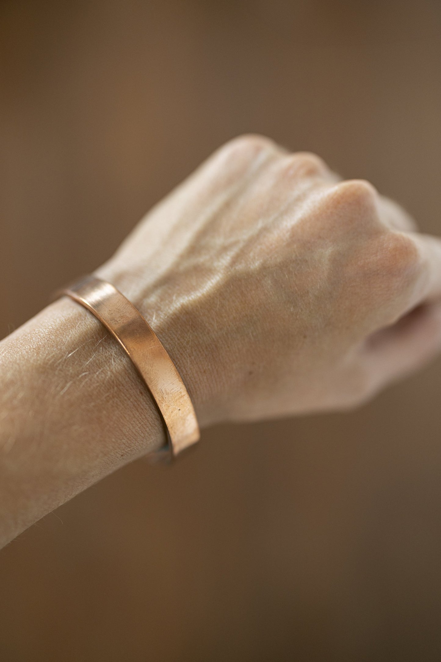 Bracelet en cuivre Kopero Lisse au poignet, gros plan sur la manchette plate en cuivre