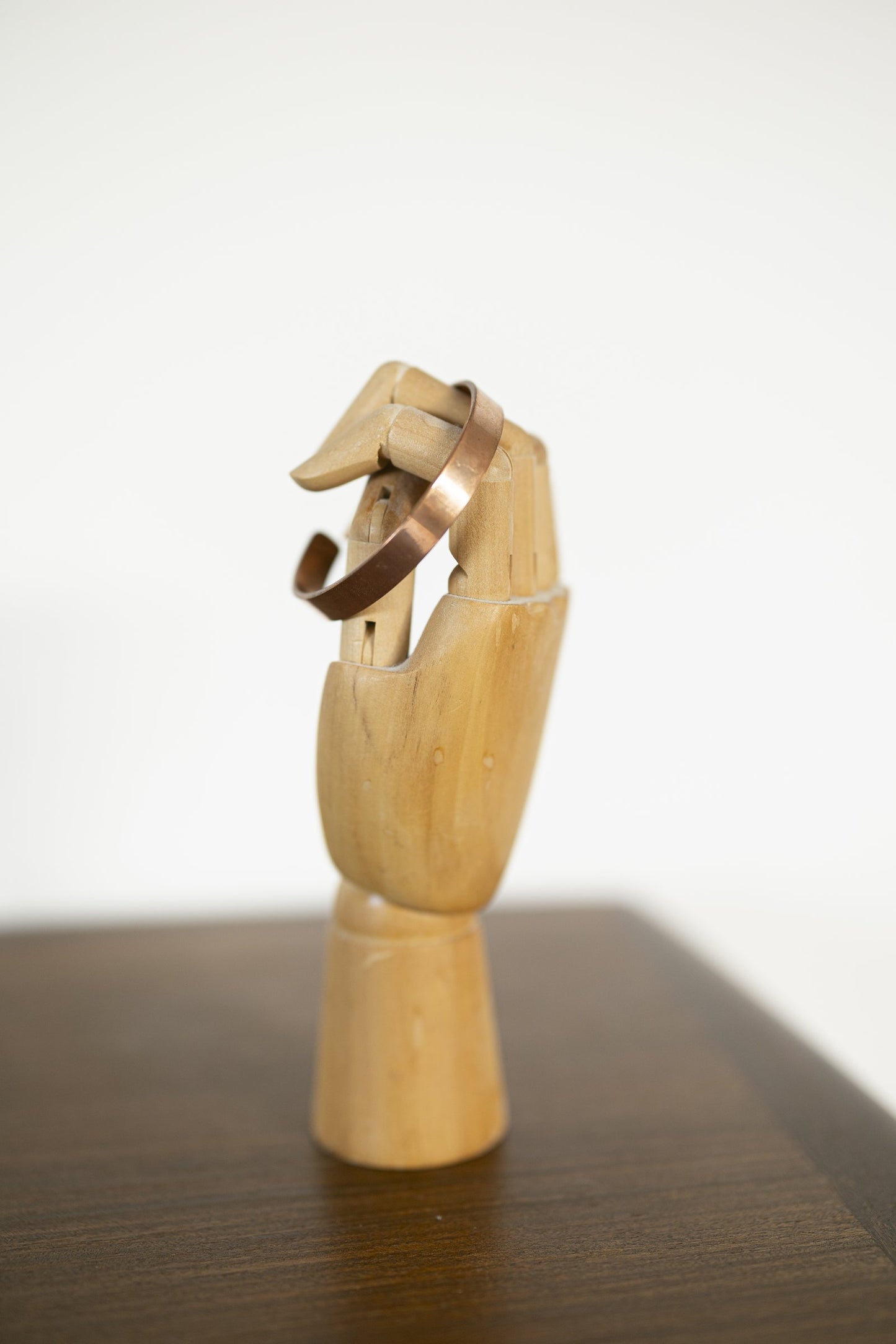 Bracelet en cuivre Kopero Lisse sur un présentoir à bijoux en bois