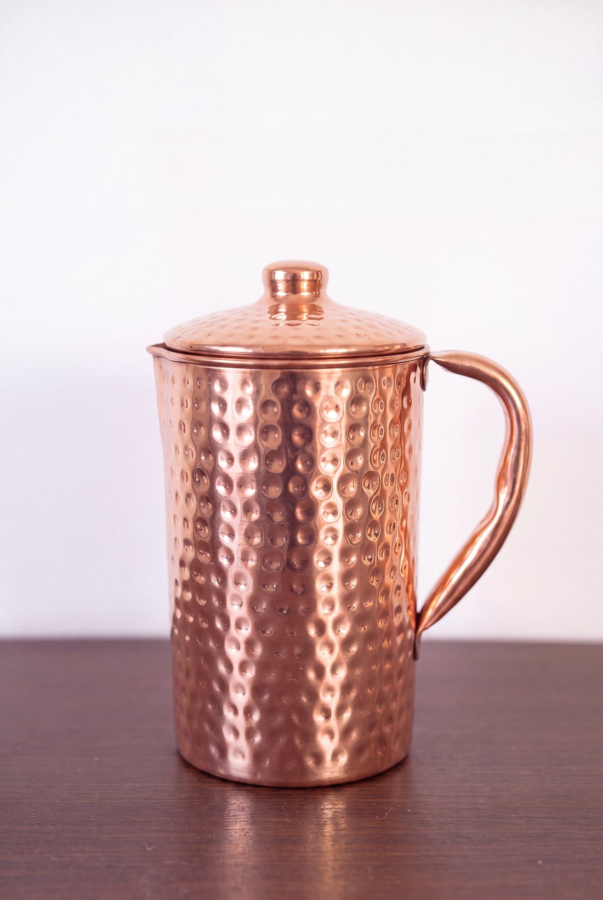 Cruche en cuivre Kopero Martelée de 1,4 litre avec couvercle sur une table en bois