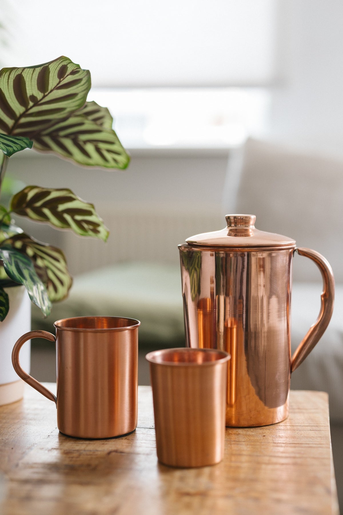 Kopero Koperen Kan Glad, met een mok en een beker op een houten tafel