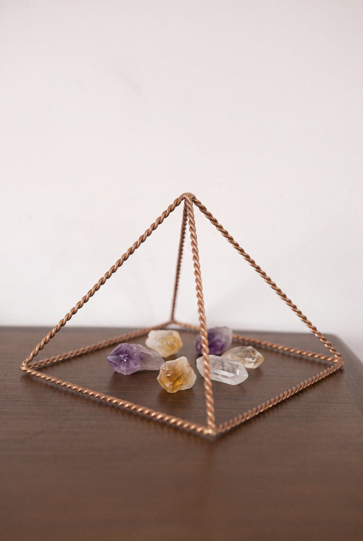 Pyramide énergisante en cuivre torsadé Kopero Petite (14,56 cm) au-dessus d'améthyste et de citrine