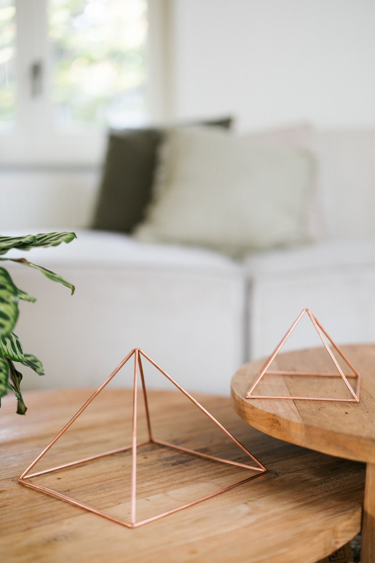 Kopero Koperen Piramide Energizer Glad, de kleine en de grote piramide naast elkaar op twee houten tafels