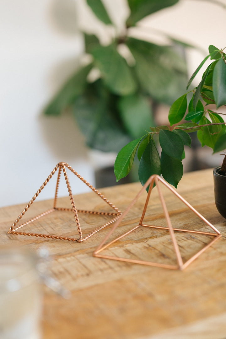 De kleine gladde en de kleine gedraaide piramide naast elkaar op een houten tafel