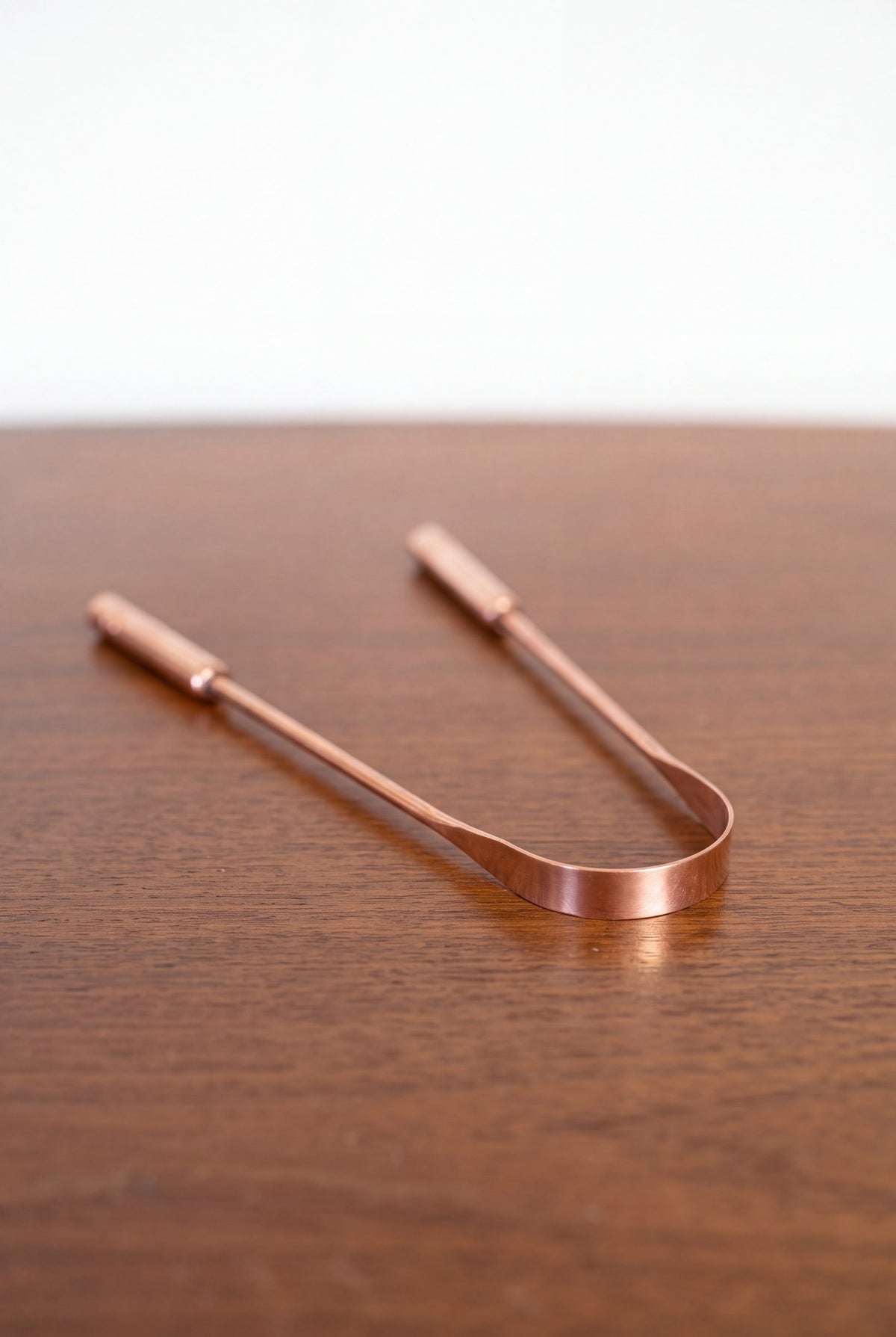 Racle-langue en cuivre Kopero en cuivre pur sur une table en bois