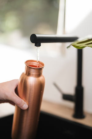 Kopero Koperen Waterfles Glad, onder de kraan, terwijl er water in stroomt